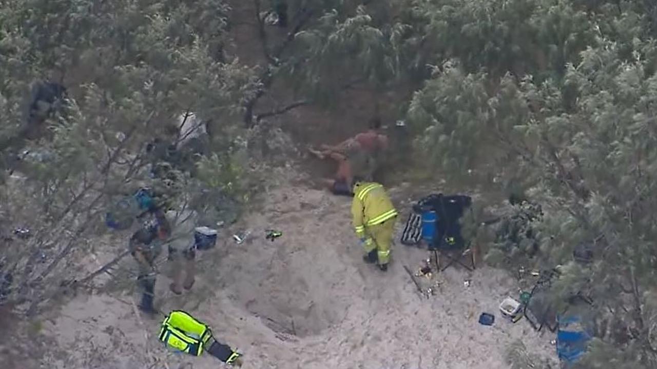 Queensland Paramedics and an RACQ Lifeflight rescue helicopter crew were called to help Mr Taylor after he fell into a hole and was buried in sand on Bribie Island, north of Brisbane. Picture: Supplied / Channel 9