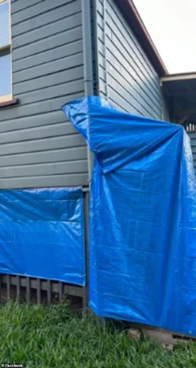 The makeshift shower is attached to the outside of the home and is covered in blue tarpaulin
