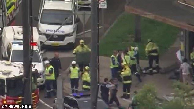 A man has been charged with a string of offences after he allegedly fled the scene when his van hit a woman walking along the footpath. Pictured are emergency responders at the scene