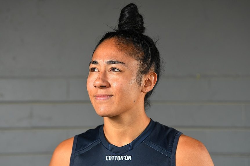 Carlton's Darcy Vescio smiling and looking up, in front of a grey wall at an AFLW press event in 2020
