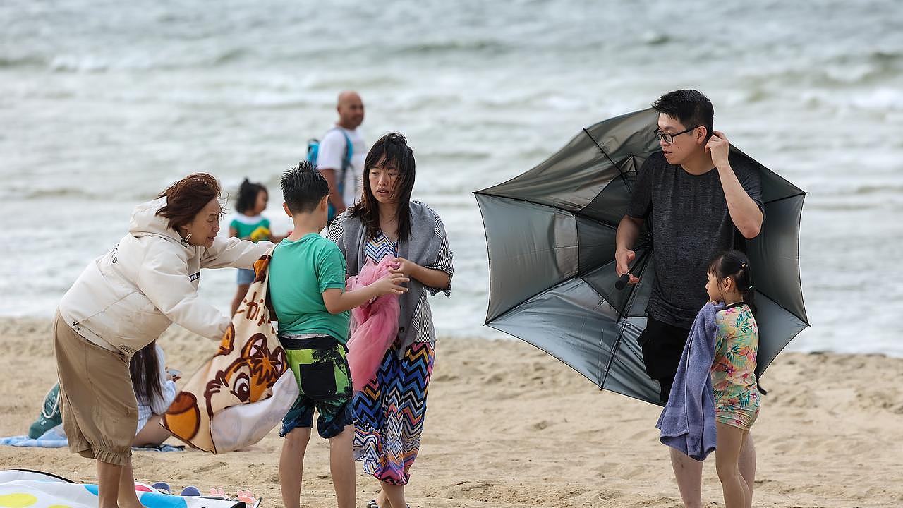 Beachgoers in St Kilda were forced to run from the incoming storm. Picture: NCA NewsWire / Ian Currie