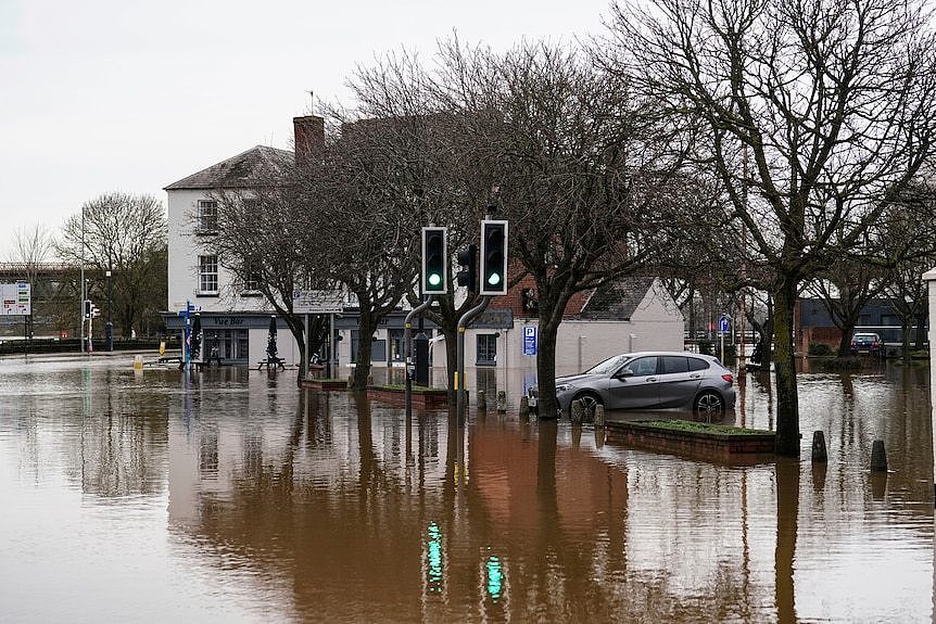 A flooded street with traffic lights and trees in Worcester, England