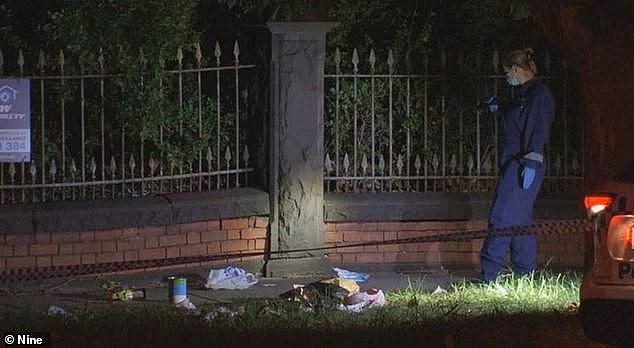 A woman is fighting for life after she and the man she was with were stabbed while walking along Dandenong Rd in St Kilda East. A police officer searching for evidence is pictured