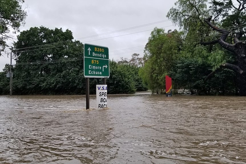 A road sign surrounded by flood water.