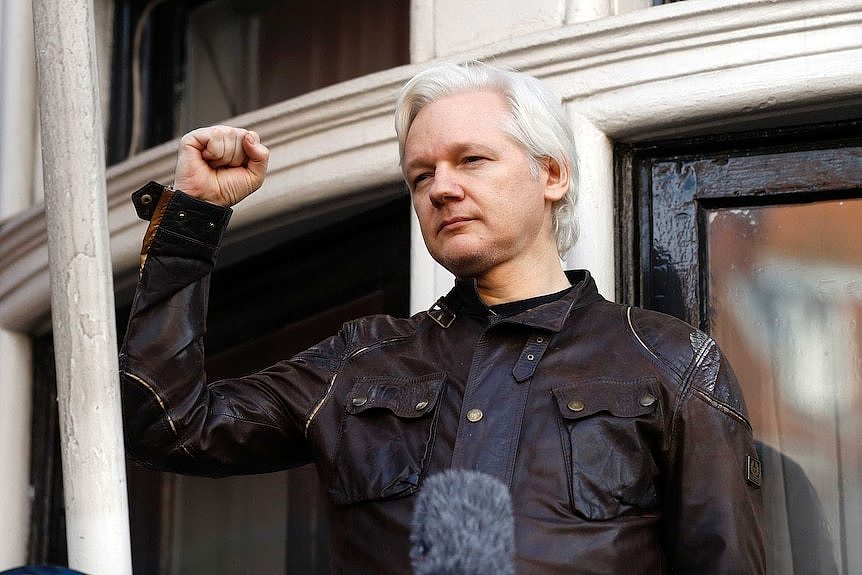 Julian Assange greets supporters outside the Ecuadorian embassy in London.