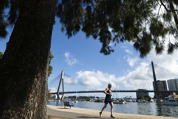 A runner enjoys the sunshine at Blackwattle Park before forecast rain sweeps in.