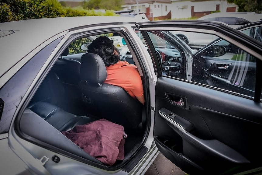 Shan sleeping in his car.