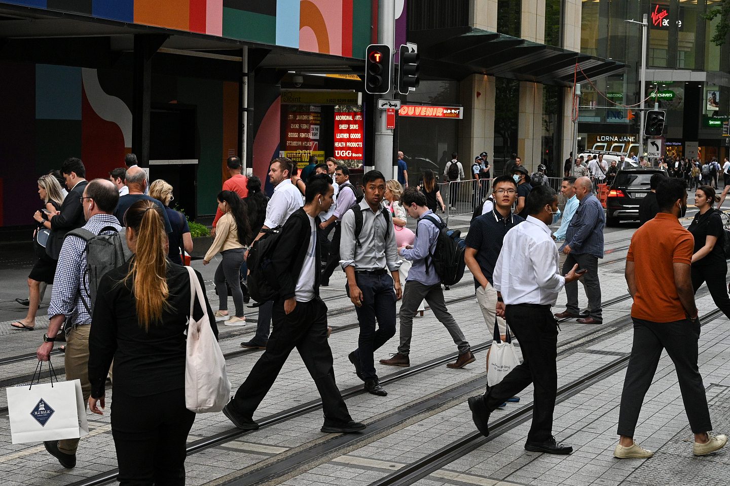People cross a street in the city centre in Sydney