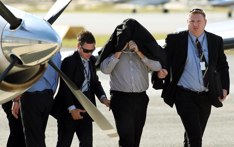 Back in Perth: Murder suspect Cameron Mansell with detectives after he arrived at Jandakot Airport yesterday. 