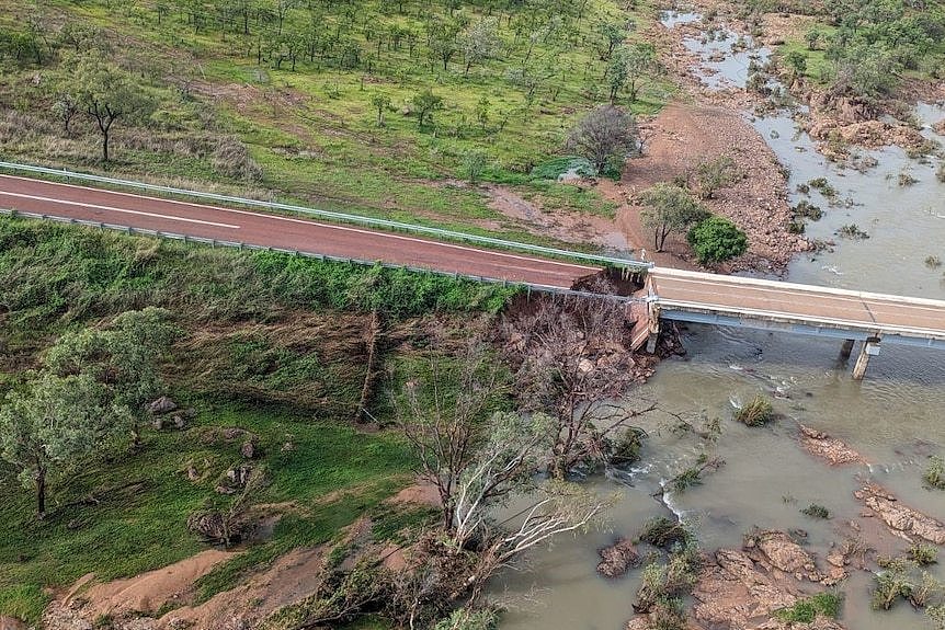 Aerial photo of damaged bridge missing a huge chunk and 4wd