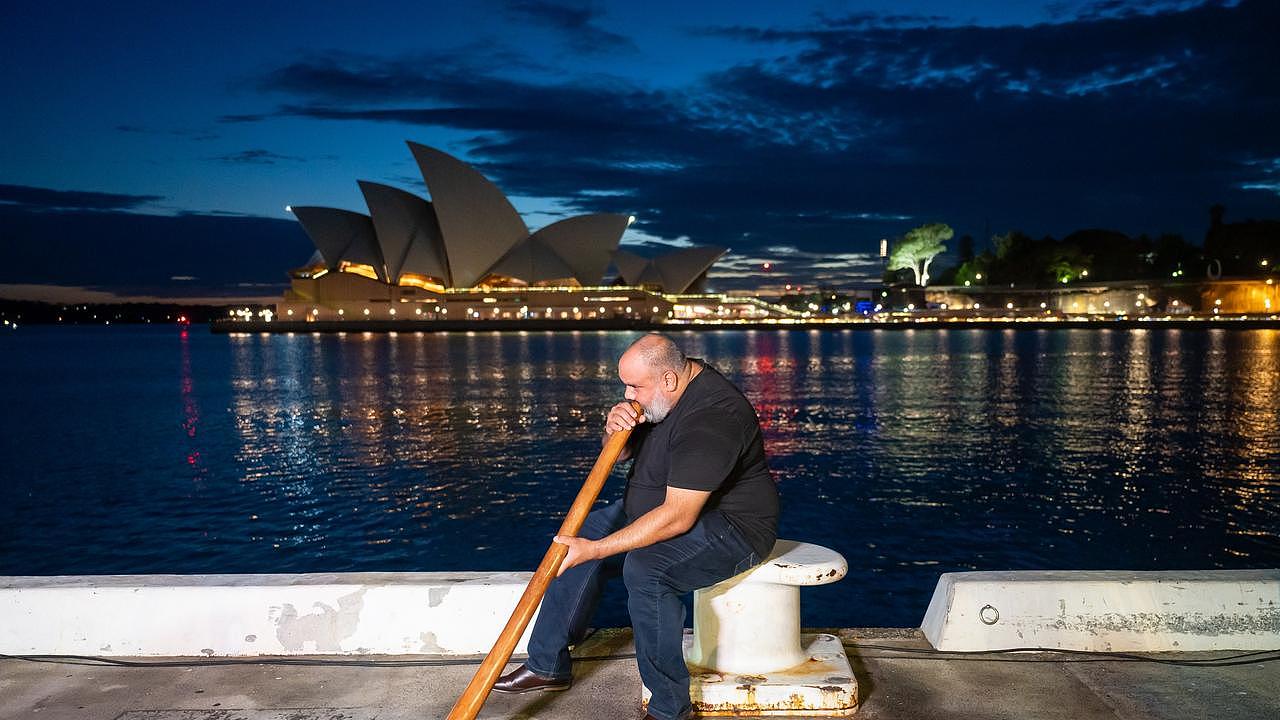 Nathan Scott plays the didgeridoo before the sails of the Sydney Opera House are illuminated by a projection of Indigenous artwork. Picture: Wendell Teodoro/Getty Images