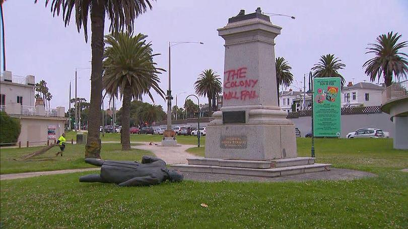 A 110-year-old Captain Cook statue in a Melbourne park has been cut at the ankles and toppled off its stone base just hours before Australia Day. The bronze statue in St Kilda's Catani Gardens was cut from its stone base shortly before 3.30am on Thursday. Vandals spray painted 'the colony will fall' in red on the memorial base and left the statue hacked off at its ankles - lying face down in the grass. Workers have arrived at the park in Jacka Boulevard to take away the broken statue using a crane and to wash off the graffiti ahead of Australia Day. The base of the statue was covered in shattered glass and one of the stone steps was torn off.