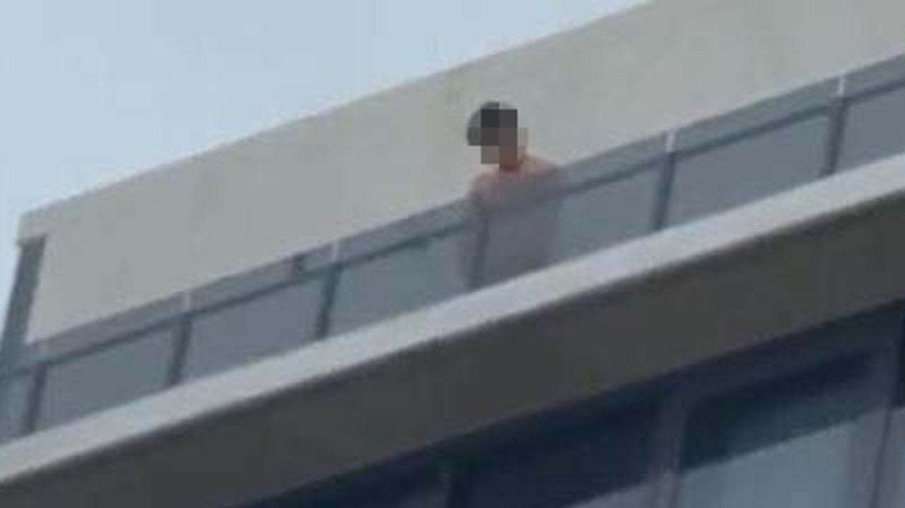 One youth urinates from the top floor onto the street.