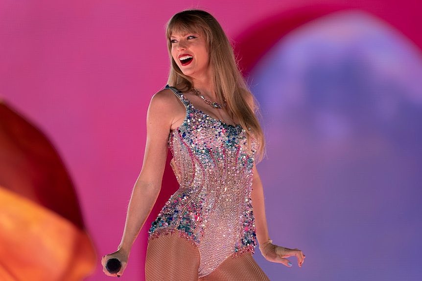 Taylor Swift smiles as she performs on stage.