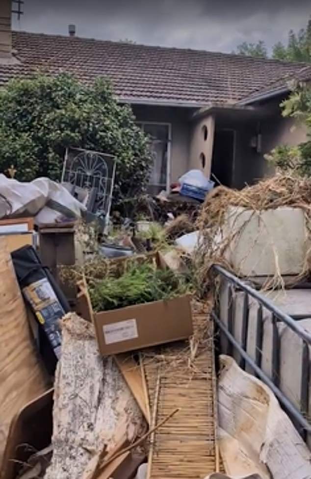 The woman claims the junk heap (pictured) is crawling with rats the size of her toy poodle and poses a serious fire hazard