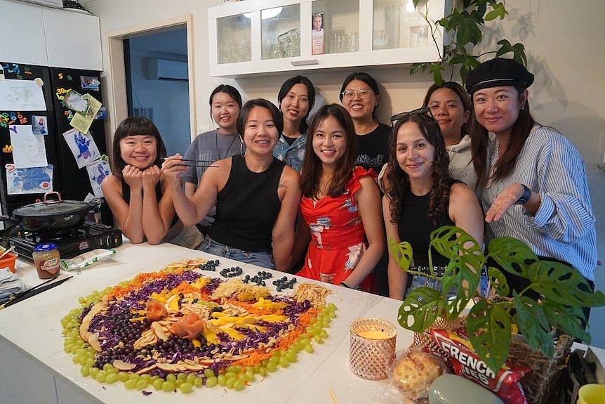 Factory workers from different cultures celebrate Chinese New Year traditions smiling.