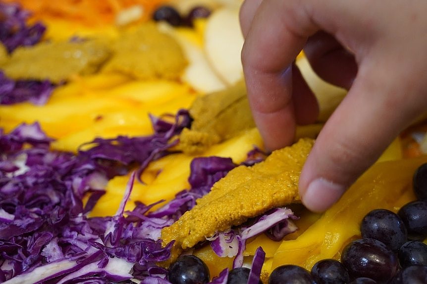 purple cabbage next to an orange sea urchin roe piece