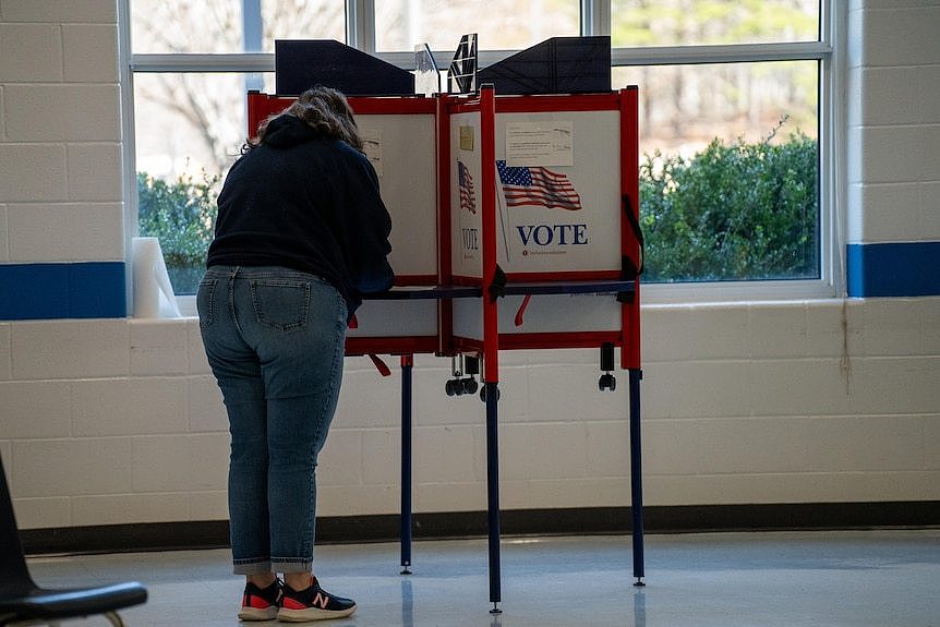 超级星期二，一名妇女在弗吉尼亚州夏洛茨维尔的贝克巴特勒小学投票。