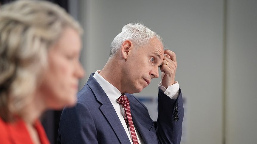 Andrew Giles scratches his head at a press conference at parliament house