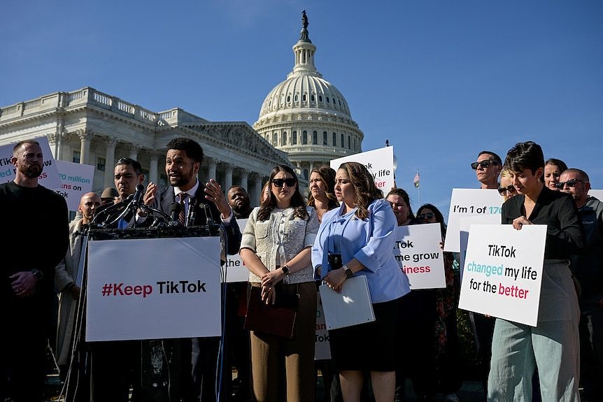 A group of people picket around a podium 