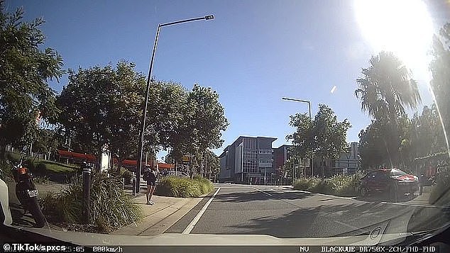 The footage showed the woman standing in a parking spot on a busy Gold Coast street