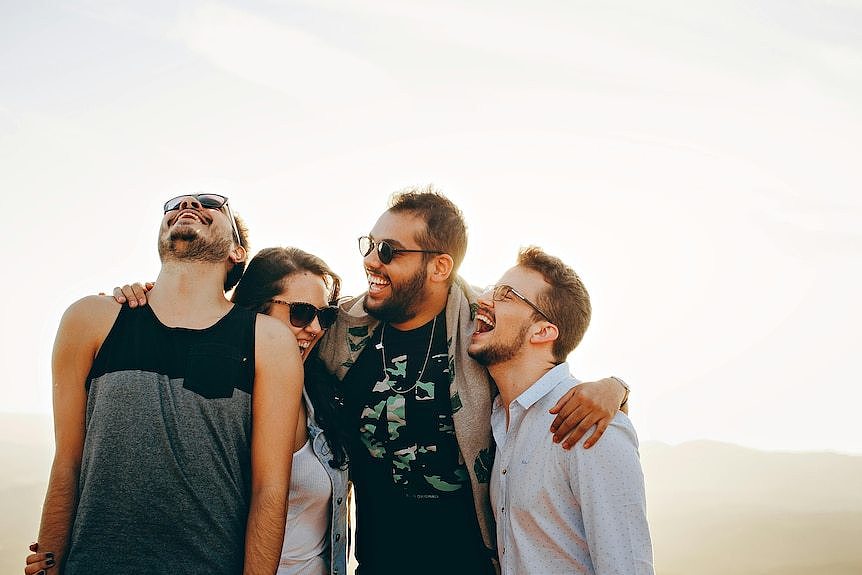 a group of young people smile together, generic image outdoors 