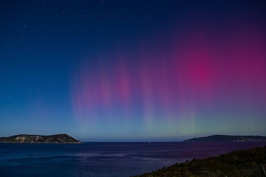 Spectacular lights in the sky over a stretch of coastline.