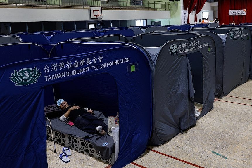A man rests at a temporary reception center.