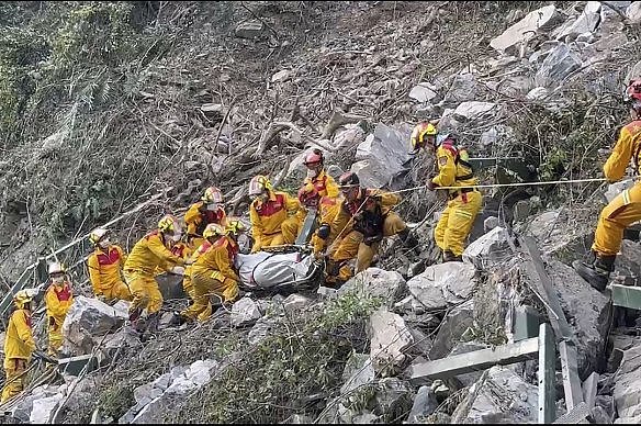 台湾东部花莲县发生强烈地震一天后，消防队员从太鲁阁国家公园疏散一具尸体。