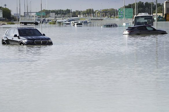 Vehicles sit abandoned in floodwaters covering a road in Dubai.