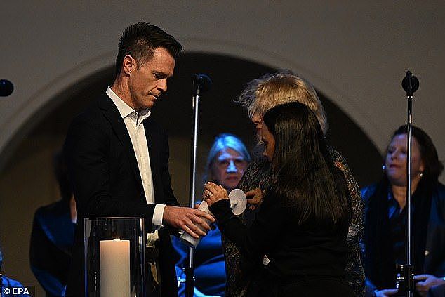 NSW Premier Chris Minns (left) lights a candle to honour the victims of the Bondi Junction tragedy at Bondi Beach