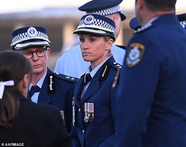 Hero cop, Inspector Amy Scott (pictured centre), was met with hugs from her colleagues as she arrived at the vigil for the victims of the attack