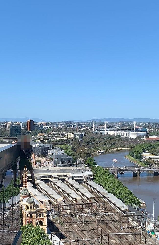 One young man hanging off the edge of a building on Flinders St. Picture: Instagram