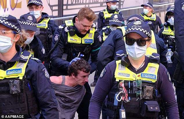 Judge Liz Gaynor of the County Court ruled the police were the 'aggressors' at a protest in Melbourne on May 29, 2021 which left a man with a dislocated arm. A man is pictured being held by police at a protest in Melbourne
