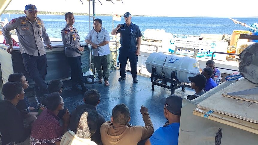 Police in Kupang, East Nusa Tenggara speak to a group of Chinese and Indonesian men