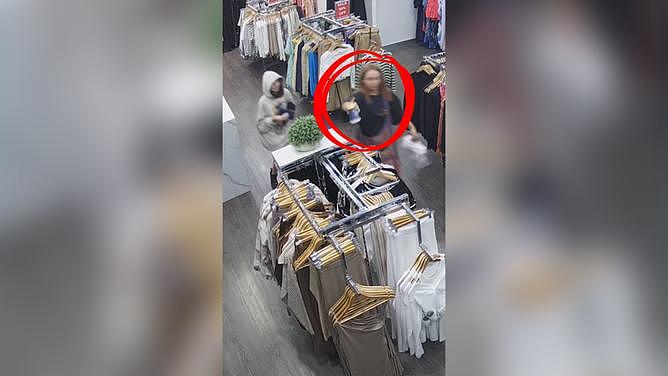In a shocking video posted online, an angry customer is caught on camera throwing the contents of a cup of coffee on a clothing rack.