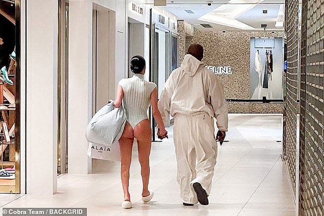 这位明星穿着一身暴露的套装，搭配白色橡胶鞋，在公共购物中心漫步时，露出了她健美的双腿