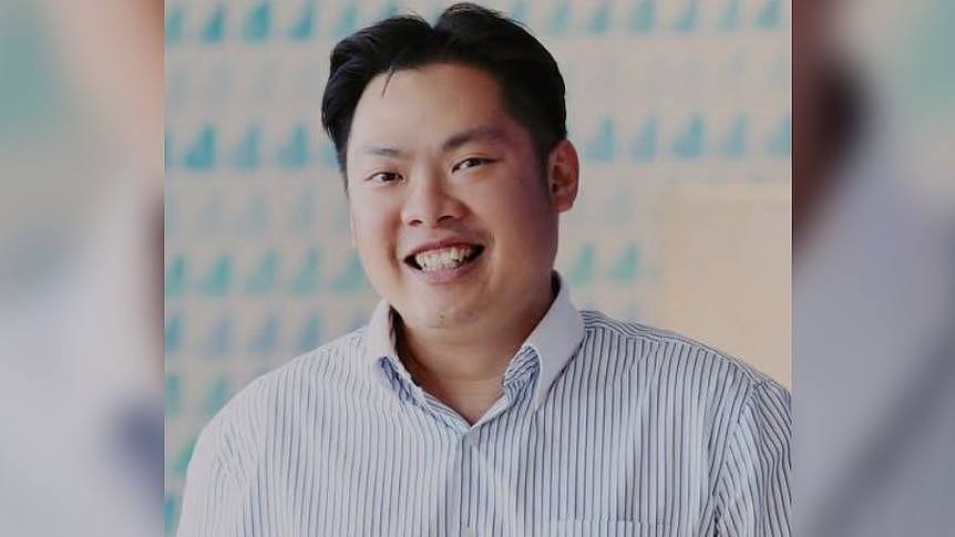A man named Luke Tham Shengen wearing a business shirt and smiling.