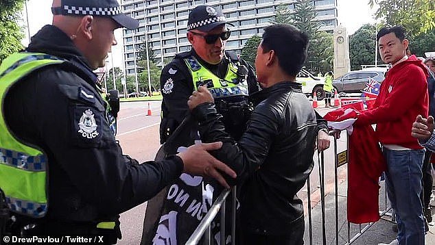 Footage of police 'targeting' a lone Tibetan protester after he waved a Free Hong Kong flag during Premier Li Qiang's motorcade has sparked fury online (pictured)