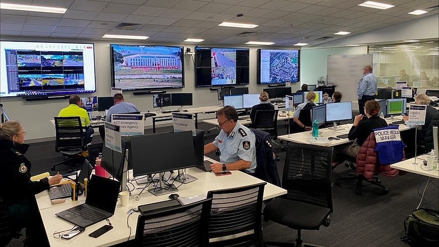 A police command room with multiple live video feeds around Canberra.