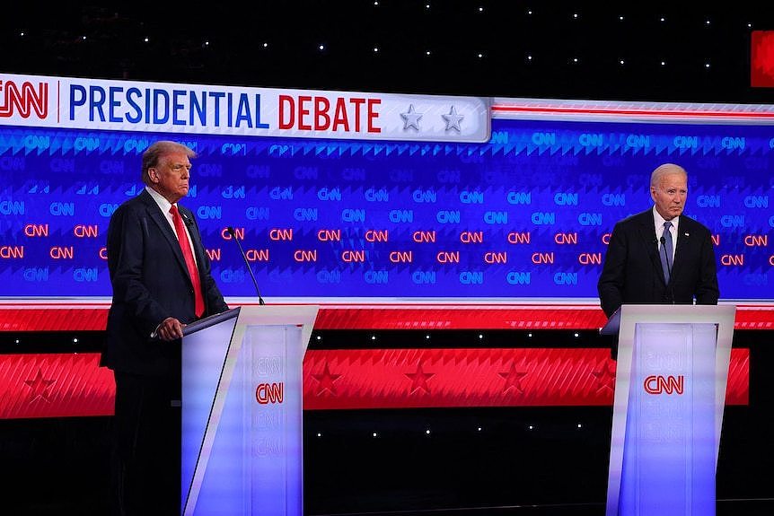 Joe Biden and Donald Trump stand on a debate stage.