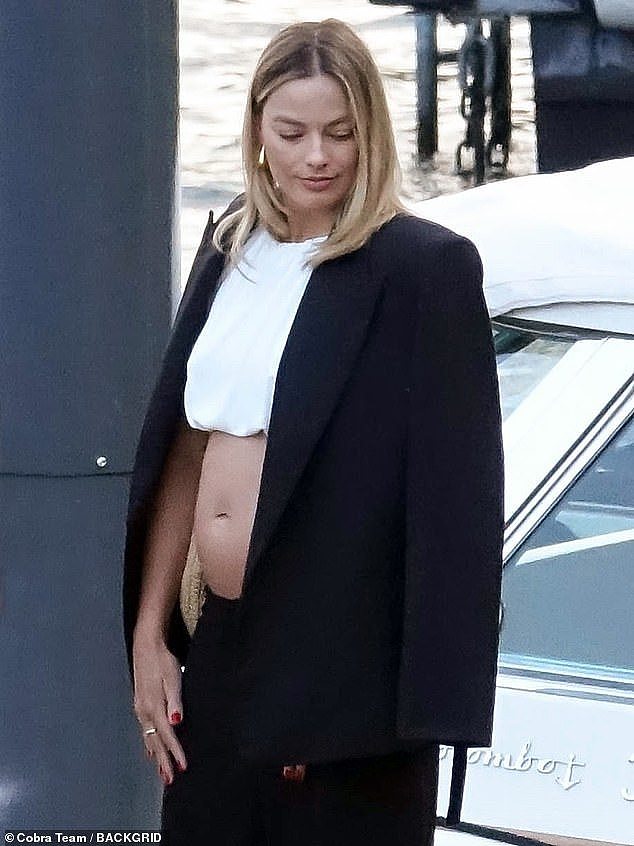 Margot Robbie flashed her midriff as she carefully boarded a boat during a holiday to Lake Como with her husband Tom Ackerley on Sunday