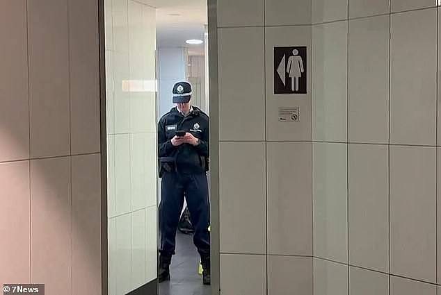 Police arrested a 21-year-old man at the shopping centre. Pictured is an officer at the scene