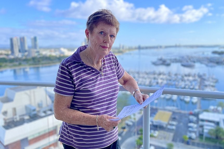 A woman stands on her balcony in main beach