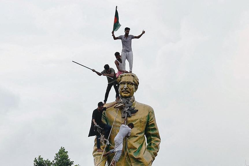 Three men on a bronze statue, waving flags 