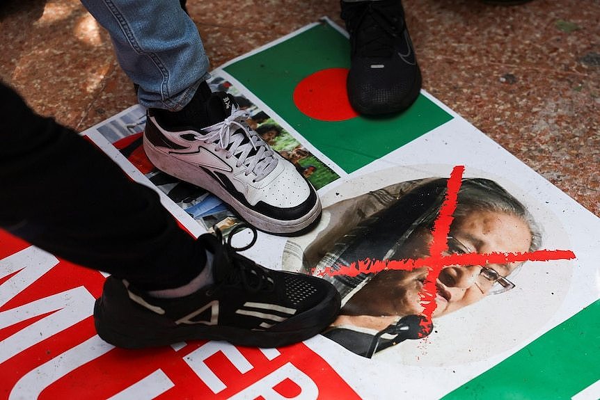 Men in sneakers stamp on a picture of a woman in a veil