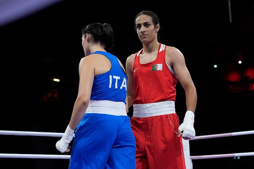 Female boxer stands in the ring and looks at camera 