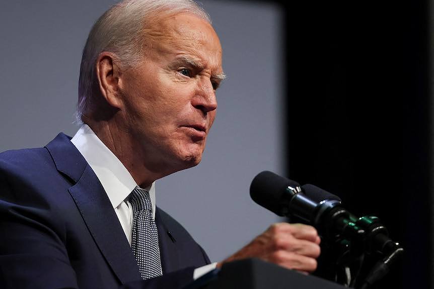 Joe Biden speaks into a microphone at a lectern