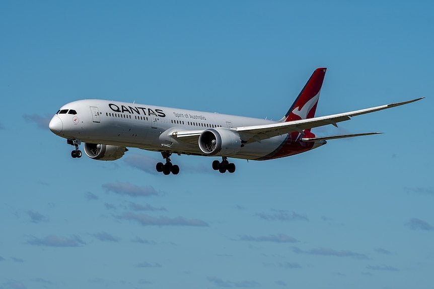 Aircraft flying against blue sky.