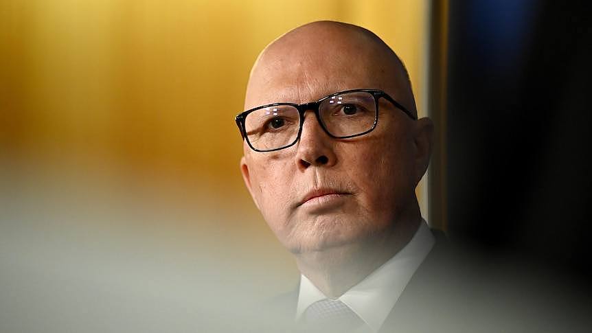 A man with glasses speaking at a press conference